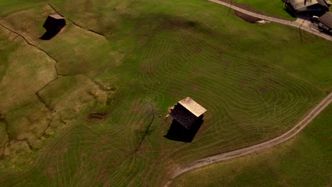 aerial-drone-footage-panning-down-revealing-springtime-tractor-lines-on-an-alpine-field