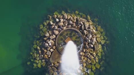 Aerial-view-around-a-Ocean-Fountain,-on-the-coast-of-Lisbon,-Portugal---down-and-orbit-movement,-drone-shot