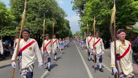 The-parade-of-royal-soldiers-or-Bregodo-in-historical-costumes-during-the-celebration-of-the-founding-of-the-city-of-Bantul,-they-are-very-energetic-and-charismatic-when-walking