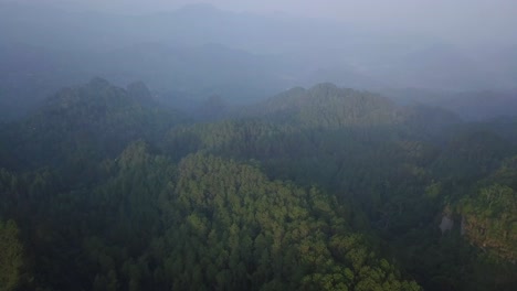 aerial-drone-view-of-forest-with-slightly-foggy-weather-on-Menoreh-Hill,-Magelang,-Indonesia