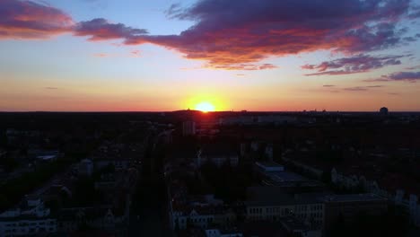 Sun-sets-over-a-city-with-pink-Cotton-candy-clouds-Dramatic-aerial-view-flight-panorama-overview-drone-footage-Berlin-Steglitz,-golden-hour-Summer-2022-view-from-above-Tourist-Guide-by-Philipp-Marnitz
