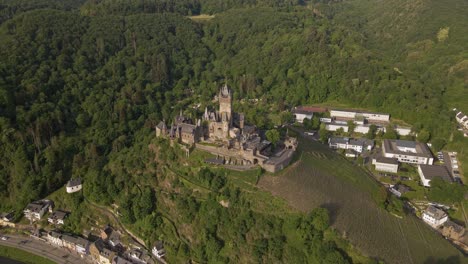 Aufsteigende,-Bogenförmige-Luftaufnahme-Der-Burg-Cochem-Mit-Dem-Morgensonnenaufgang