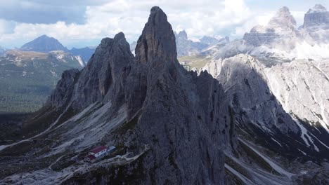 A-stunning-drone-shot-of-a-lonely-house-located-in-the-middle-of-the-mountains-and-rock-formations-of-the-Dolomites-in-South-Tyrol-in-Italy