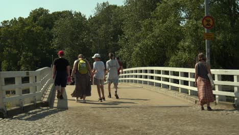Tourists-on-historic-cobblestone-street-cross-bridge-on-Suomenlinna