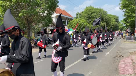 Rows-of-royal-soldiers-or-Bregodo-parade-in-historic-costumes-during-the-celebration-of-the-founding-of-the-city-of-Bantul,-while-carrying-musical-instruments