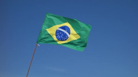 Brasilianische-Flagge-Weht-Im-Wind,-Mit-Blauem-Himmelshintergrund