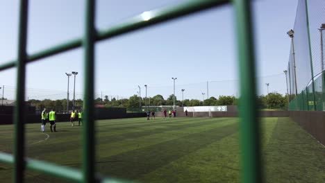 An-abstract-shot-of-two-soccer-teams-getting-ready-for-kick-off-ahead-of-a-social-game-of-amateur-5-A-Side-football-on-an-artificial-astro-turf-pitch-at-Goals-Ruislip,-England
