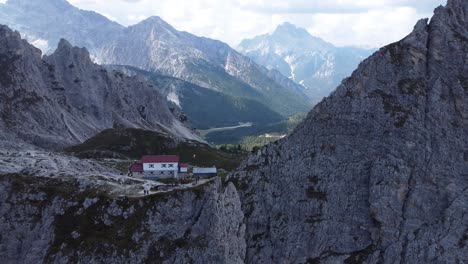 Imágenes-De-4k-De-Un-Dron-Volando-Lentamente-Lejos-De-Una-Casa-Muy-Encantadora-Ubicada-En-Medio-De-Las-Impresionantes-Formaciones-Rocosas-Y-Montañas-De-Los-Dolomitas-En-El-Tirol-Del-Sur-En-Italia
