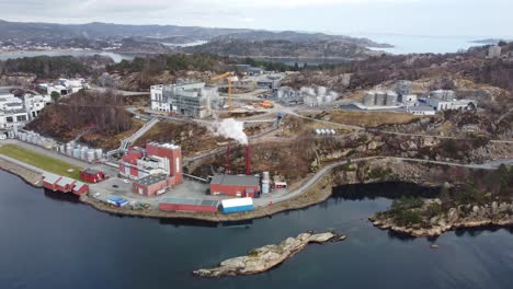 GE-healthcare-industrial-area-and-production-facilities-in-Lindesnes-Norway---Panoramic-aerial-showing-massive-plant-with-smoke-coming-from-chimneys-and-ocean-background
