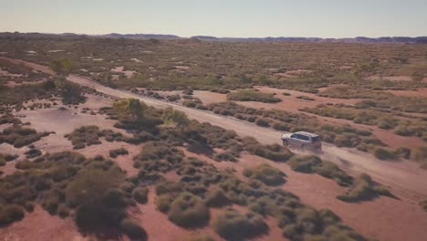 Drone-Aéreo-Siguiendo-4wd-Por-Camino-De-Grava-Sobre-El-Vasto-Desierto-Australiano