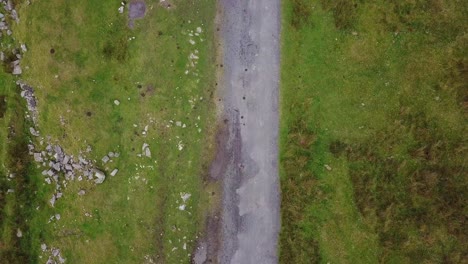 An-aerial-fly-over-of-a-narrow-road-in-Dartmoor-National-Park-in-Devon