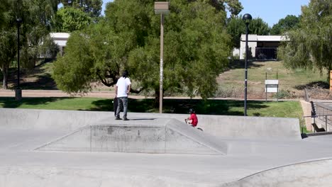 Mann-Beobachtet-Jungen,-Wie-Er-Sein-Fahrrad-Im-Wedge-Skatepark-In-Scottsdale,-Arizona,-Richtig-Richtet