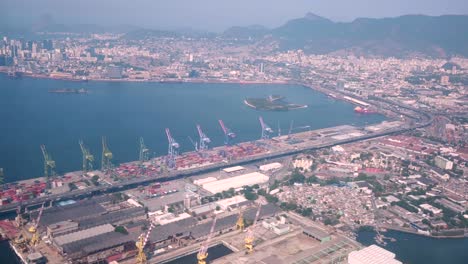 Flying-over-the-port-area-of-Rio-de-Janeiro-with-its-machinery-and-stock-areas-and-in-the-background-the-city-centre-with-recognisable-famous-landmarks