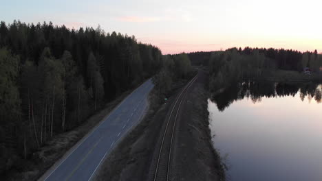 A-drone-view-of-a-lonely-road-between-a-forest-and-the-water's-edge