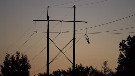 Debris-hang-on-hydro-lines-before-a-warm-summer-sunset-after-a-huge-storm-tore-through-Ottawa,-Ontario