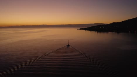 Following-sailboat-on-Lake-LÃ©man-with-beautiful-sunset-colors-In-front-of-Cully,-Lavaux---Switzerland