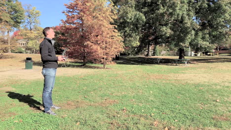 A-drone-operator-flies-his-drone-on-a-beautiful-fall-day-in-the-park