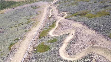 Young-man-biking-downs-curving-on-a-dowhill-biking-track-in-Lapland-Finland