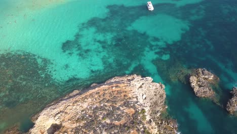 Nadadores-Y-Buceadores-Llenan-El-Agua-Y-Disfrutan-Del-Paisaje-De-La-Laguna-Azul,-Sitio-De-La-Película-Original-Ambientada-En-Malta