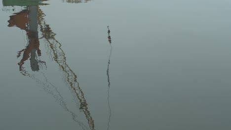 Reflections-of-port-crane-in-calm-water-at-Port-of-Liepaja-in-foggy-day