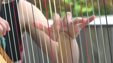 Hand-picking-strings-on-harp
