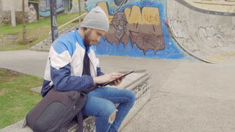 young-man-using-tablet-in-a-park