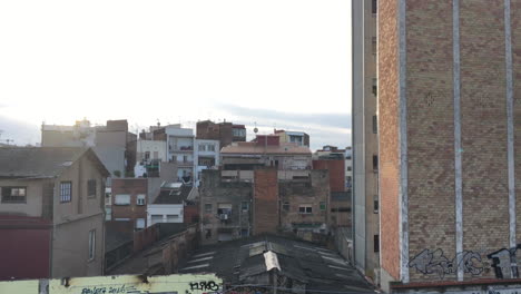 Barcelona-Sants-abandoned-warehouse-and-buildings-panoramic-panning-shot-in-morning-daylight-with-houses-and-sun-flare