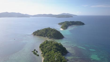 Luftaufnahme-Von-Kleinen-Inseln-Mit-Vegetation-Und-Weiteren-Inseln-Am-Horizont-Auf-Den-Philippinen-–-Kameraführung-Rückwärts,-Sockel-Nach-Unten