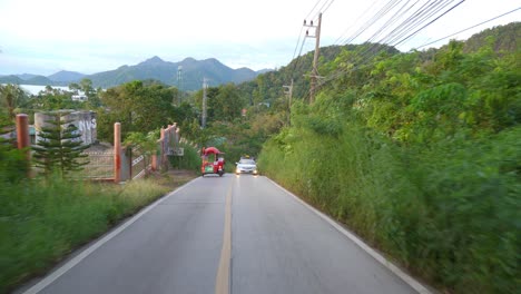 dash-cam-behind-the-car,-toyota-driving-up-a-steep-hill-on-an-island-Slowmo