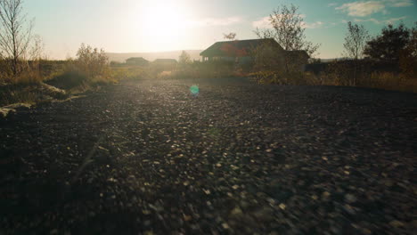 Low-angle-moving-down-a-gravel-road-at-sunset---animal-POV-close-to-the-ground