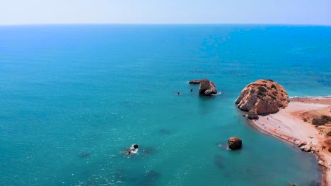 Aerial-drone-shot-flying-out-to-sea-towards-Aphrodite's-Rock-in-Cyprus