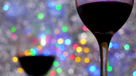 Close-up-of-Red-Wine-in-glasses-on-colorful-bokeh-and-silver-blanket-close-up-in-a-romantic-intimate-atmosphere