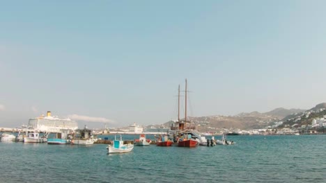Boote-Legten-An-Einem-Hafen-In-Mykonos-An,-Als-In-Der-Ferne-Ein-Kreuzfahrtschiff-Ankam