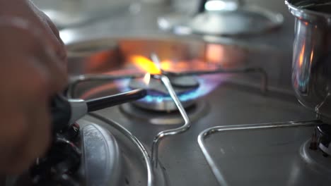 SLOWMO-Close-up---Lighting-up-gas-stove-burner-fire-and-a-pot-of-water-in-kitchen-of-motorhome