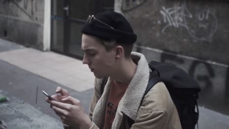 Young-man-reading-message-on-his-mobile-phone