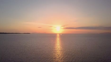 Luftaufnahme-Des-Wunderschönen-Sonnenuntergangs-Am-Meer-In-Thailand---Kameraverfolgung-über-Wasser