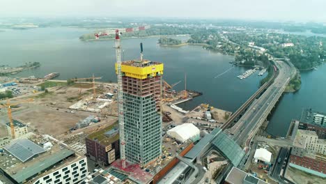Orbiting-aerial-shot-of-a-tall-building-under-construction