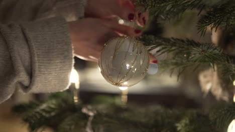 Cámara-Lenta:-Mujer-Con-Bola-De-Navidad-En-La-Mano-Decora-El-árbol-De-Navidad-Por-La-Noche