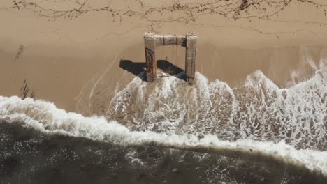 Aerial-View-of-old-broken-pier-made-of-cement-in-the-middle-of-the-ocean-near-Santa-Cruz-California