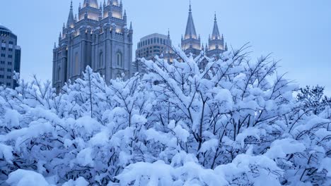 Early-Morning-view-of-the-Mormon-Temple-in-Salt-Lake-City,-Utah-in-the-pre-dawn-hour-after-a-heavy-snow-storm---panning-up-to-reveal-the-building