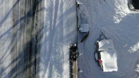 Aerial-top-view-man-with-snow-blower-zoom-out