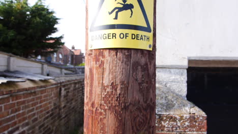 Camera-rising-up-a-telegraph-pole-with-a-danger-sign-at-the-top