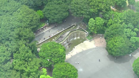 still-aerial-view-close-up-waterfall-in-park-with-people