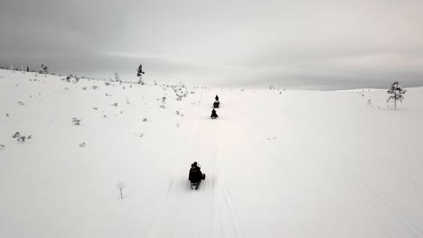 Drone-view-of-snowscootering-in-Saariselka,-Lapland,-Finland