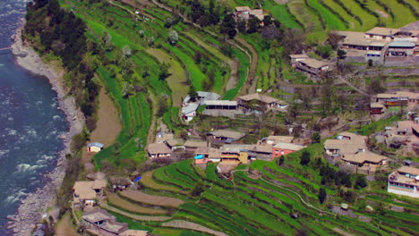 A-picturesque-village-with-beautiful-scenes-of-mountains-and-river-aerial-view,-as-well-as-charmingly-crafted-greenery
