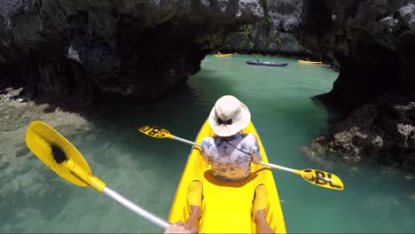 Niña-Haciendo-Kayak-En-Bote-Amarillo-En-Una-Pequeña-Laguna-En-Filipinas,-Entrando-En-La-Laguna