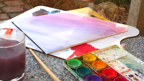 An-artist-painting-a-colorful-rainbow-gradient-with-water-color-on-a-paper