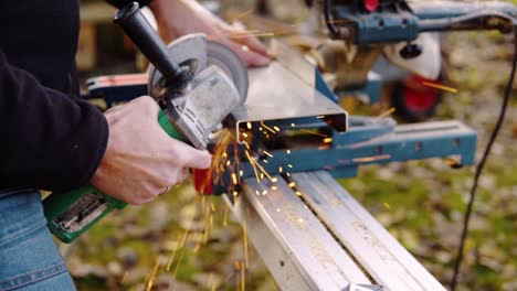 A-married-man-cutting-metal-with-angle-grinder-with-sparks-flying-around-in-slowmotion