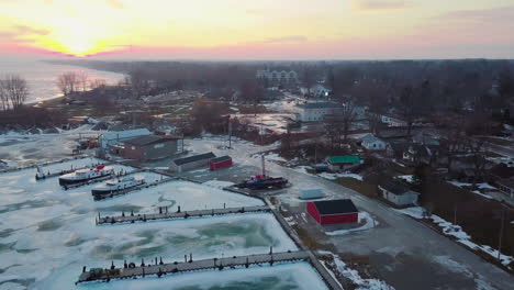 Eine-Wunderschöne-Sonnenuntergangsszene-Mit-Booten-Im-Zugefrorenen-Eriesee-Entlang-Der-Küste-Einer-Kleinen-Kanadischen-Stadt