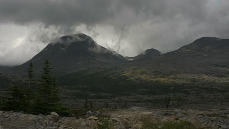 Riesige-Berge-Alaskas-Ragen-In-Der-Ferne-Auf,-Während-Wolken-Auf-Ihren-Gipfeln-Ruhen